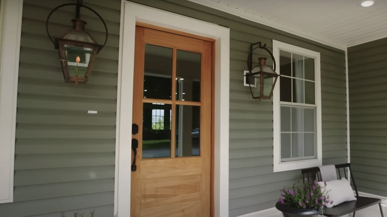 A wooden front door with a green exterior.