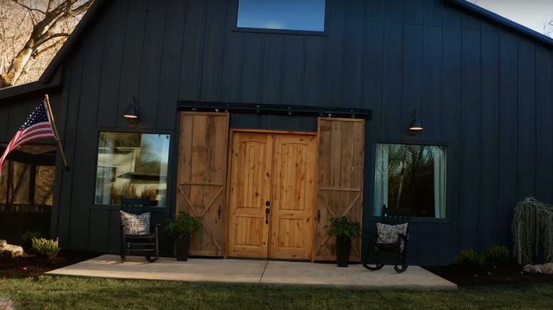 A black barn exterior with wooden barn doors.