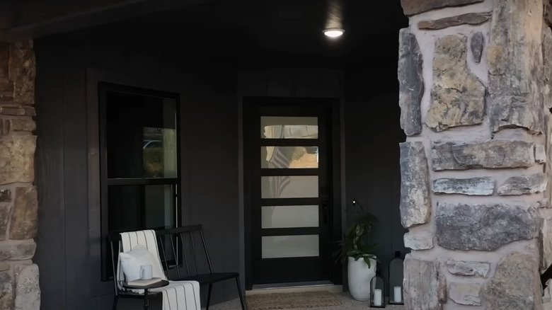 Stone support beams and a black front porch.