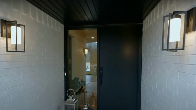 A mid-century entryway with a black front door.