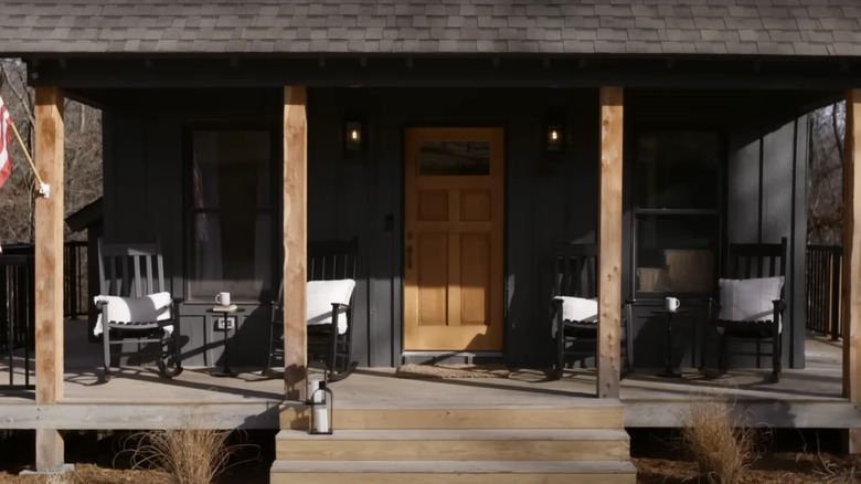 A black home exterior with a wooden front door.