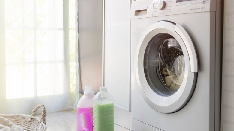 A front-loading washing machine with detergent and laundry in front