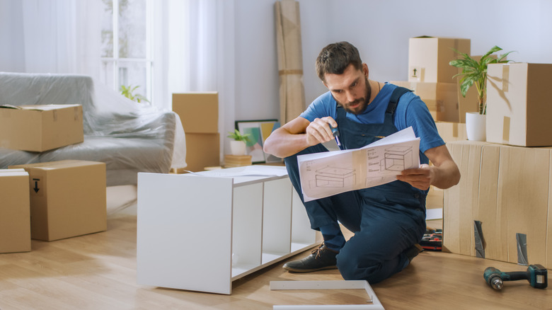 A man assembles furniture.