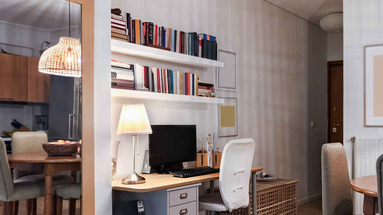 Floating bookshelves above a work station in a dining room