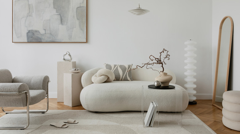 Minimalist interior with soft lighting, a boucle armchair, and sleek decorative accents. A balance of simplicity and elegance.