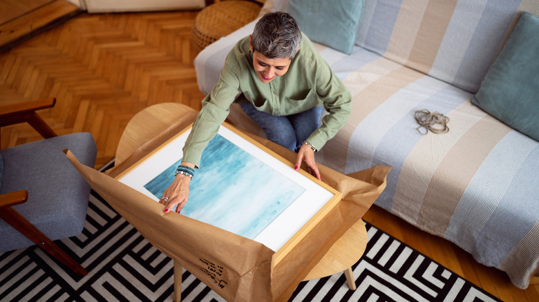 A woman unboxing a piece of art she ordered online