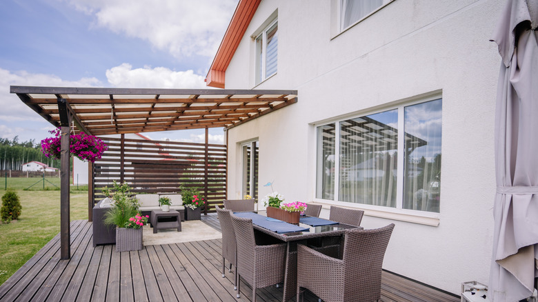 Partially covered backyard patio overlooking neighbors without much privacy.