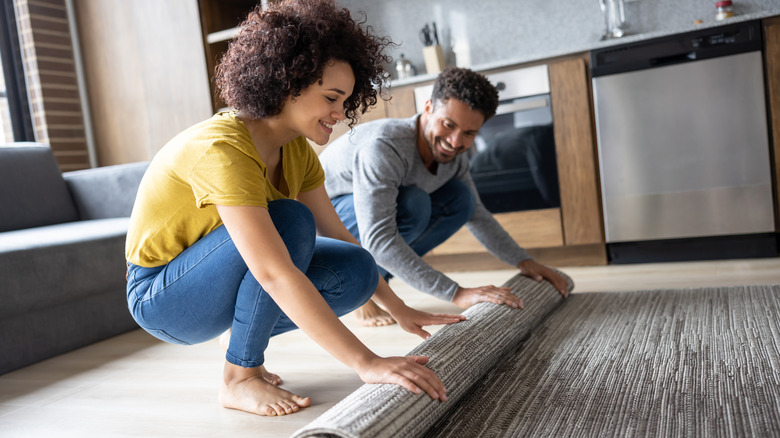 Couple unrolling area rug