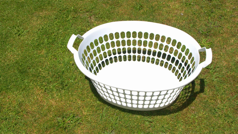 White laundry basket outside on grass