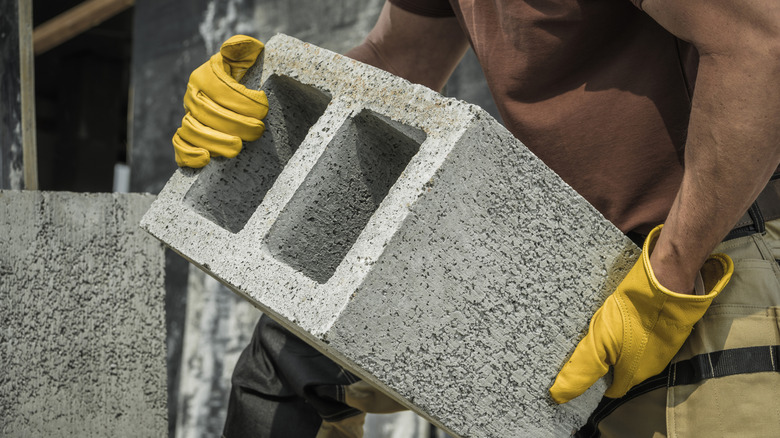 A construction worker moving a cement block