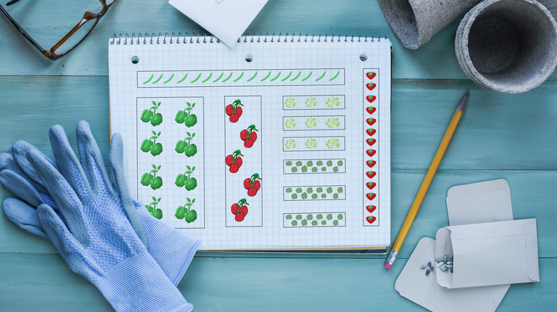 A notebook with a garden layout surrounded by garden supplies