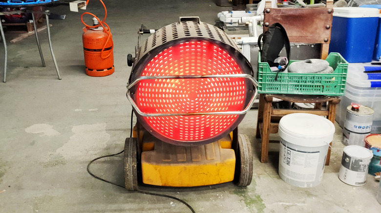 Red-hot heater in a garage, placed next to various items.