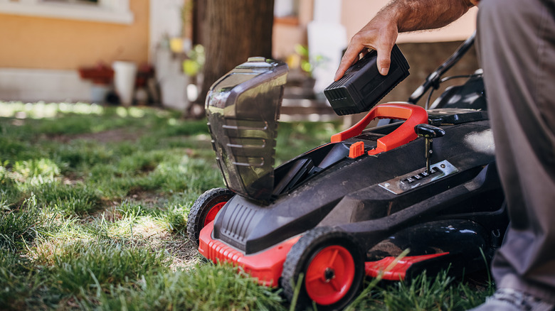 Man placing battery in mower