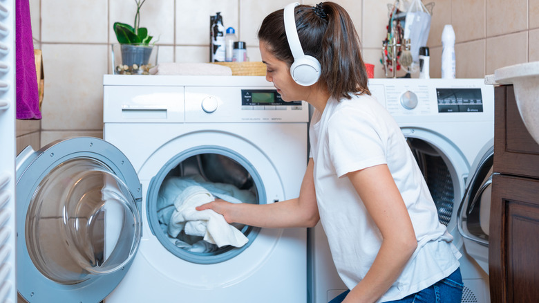 Woman taking laundry out of a white dryer