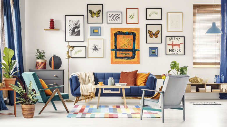 A multi-colored living room with a gallery wall of art on the wall.