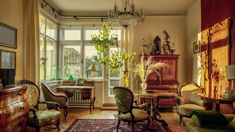 A living room filled with antique furniture during sunset.