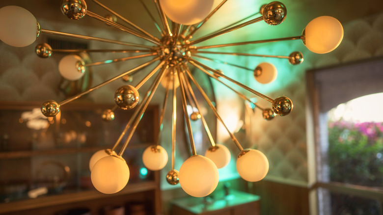 A gold sputnik chandelier hanging in a dining space.