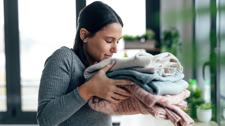 Woman holding clean fall sweaters