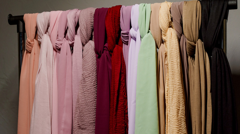 Hanging scarves on black bar