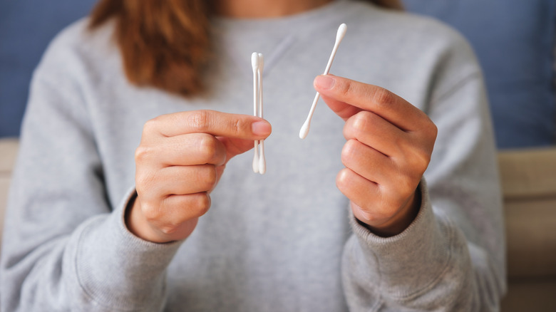 person holding q-tips