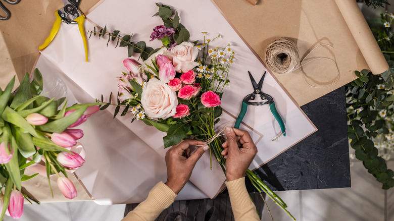 person tying flower bouquet