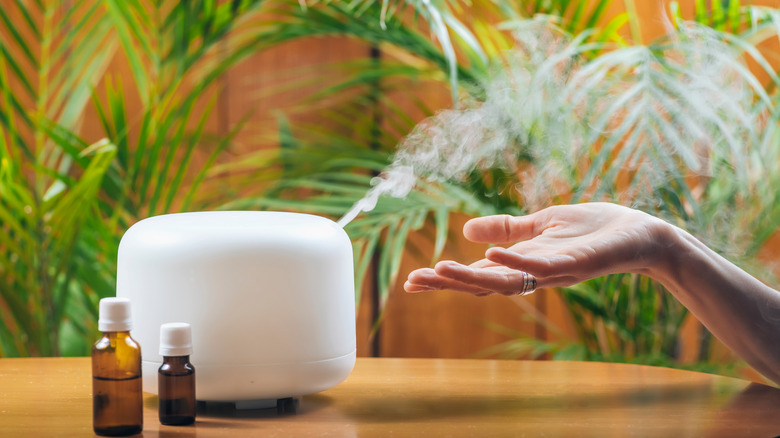 Hand using essential oil diffuser