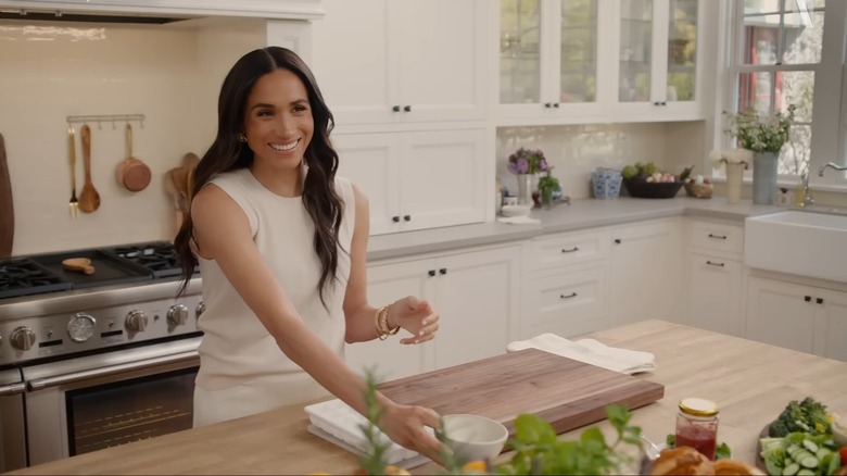 Meghan Markle, Duchess of Sussex smiling in farmhouse-style kitchen