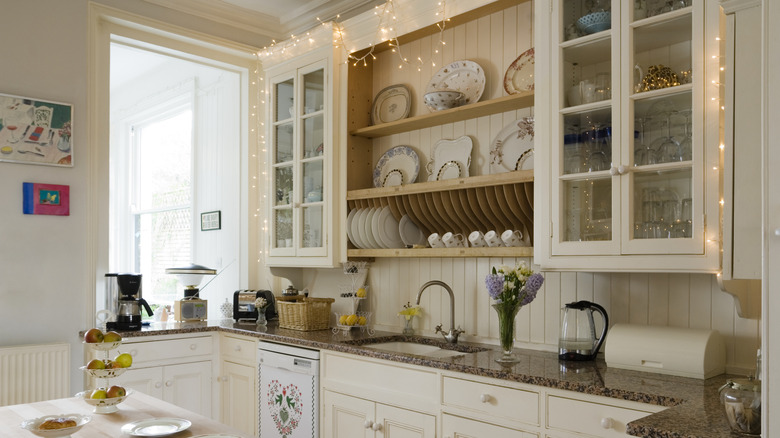 Bright and airy kitchen with beige color palette and shiplap paneling that extends up to the cabinets.