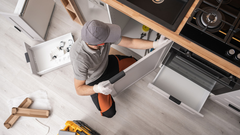 worker putting in new kitchen cabinets
