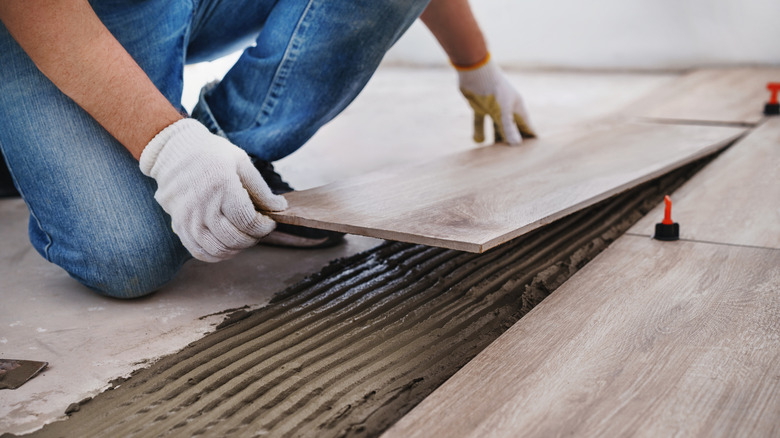 Worker installing planked flooring