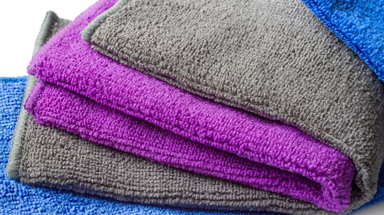 Pile of folded microfiber cloths in blue, grey, and purple shades