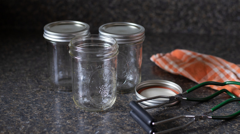 Canning jars, rings, lids, and tools on a counter