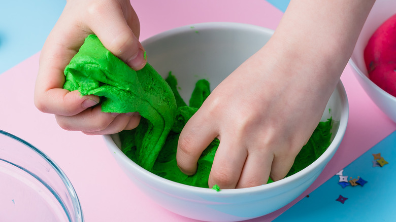hands holding green playdough