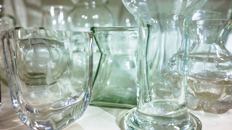 Several clear glass vases sitting on a table