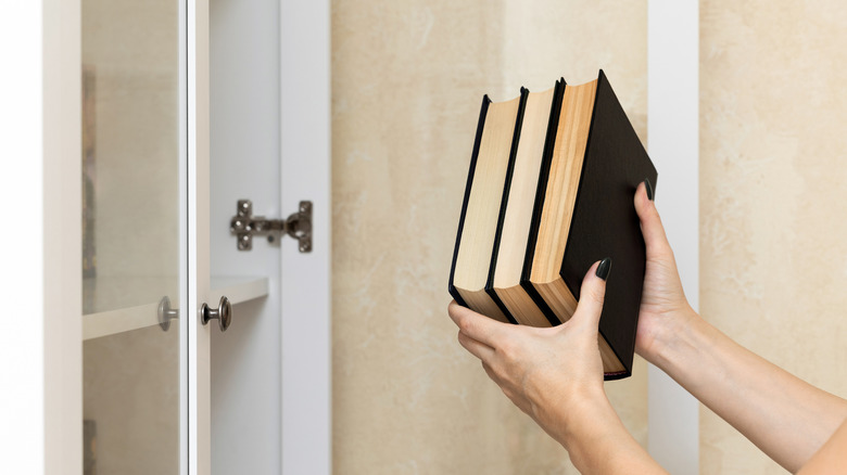 Woman holding books to put on shelf