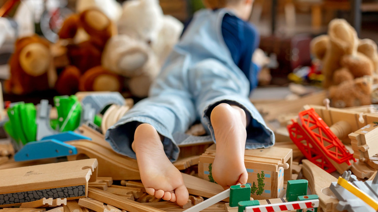 Kid laying in a room surrounded by a bunch of toys