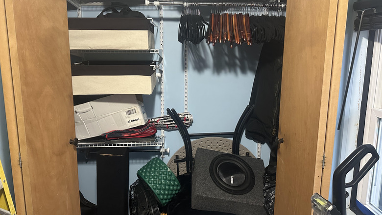 Cluttered catch-all closet with hangers, furniture, and boxes
