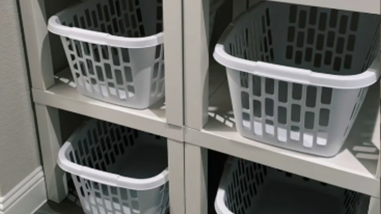 Four laundry baskets tucked underneath stacked IKEA LACK side tables