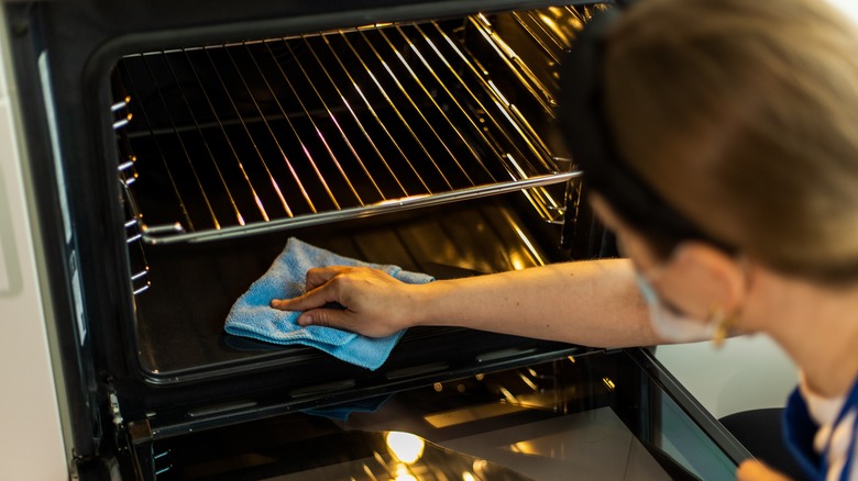 person cleaning oven