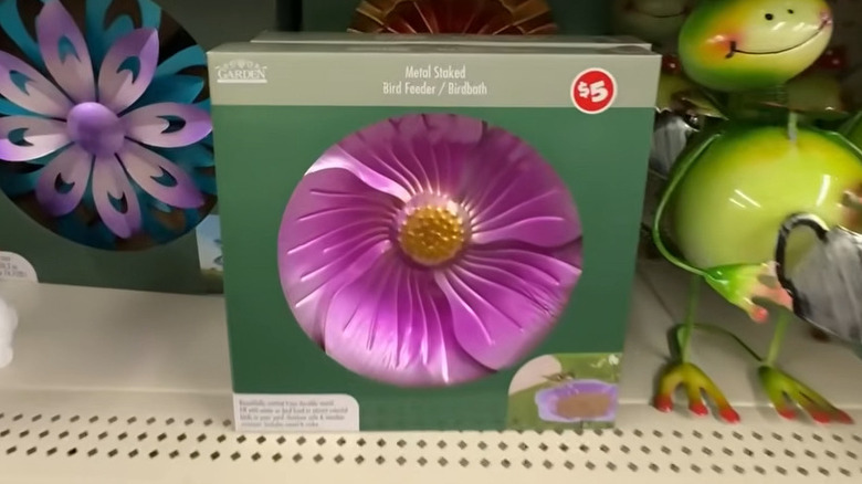 Pink metal staked bird feeder in box with a price sticker of $5 next to a metal frog on Dollar Tree shelves