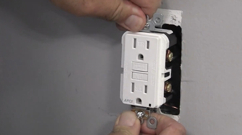 Hands of person installing an AFCI outlet.