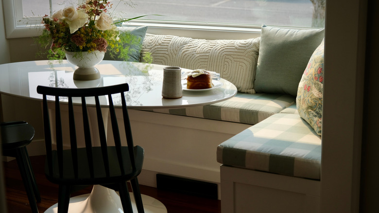 A corner bench nook with a table and chair for dining