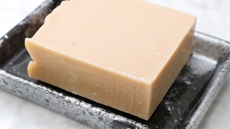 Marble look soap holder with a bar of natural soap in it.