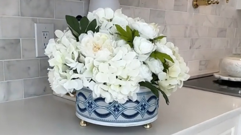 A leftover cookie-tin-turned-vase filled with flowers