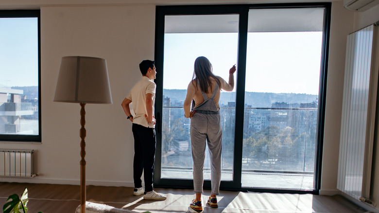 Couple looking at window in new apartment.