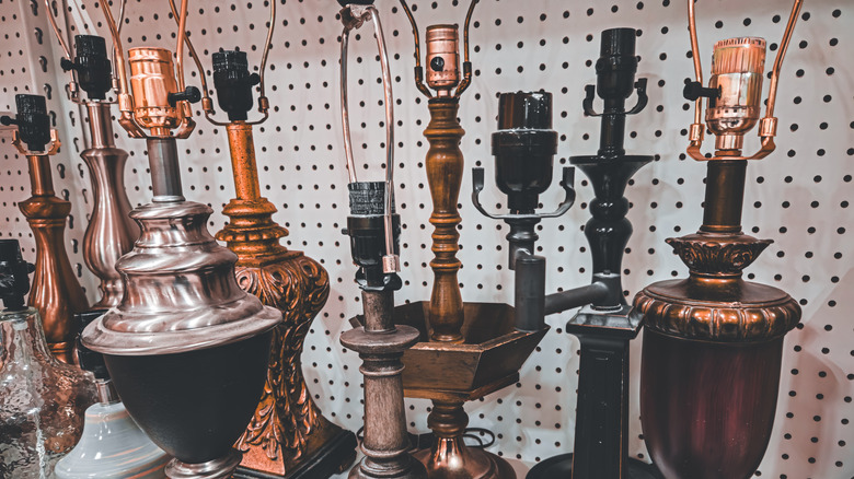 A group of vintage lamps sitting on a shelf in a vintage store