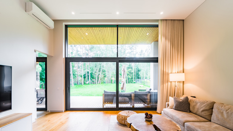 Three ceiling lights above a large window with a curtain pulled to one side