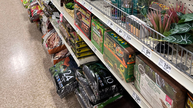 Bags of gravel on the shelves of an aquarium supply store.