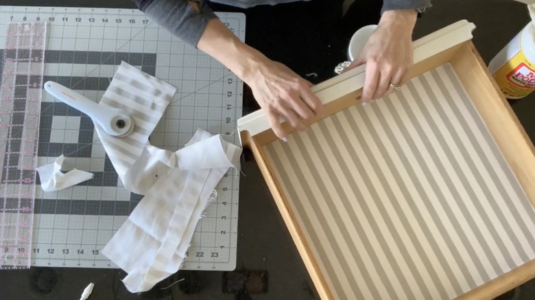 Woman placing homemade liner into bathroom drawer.