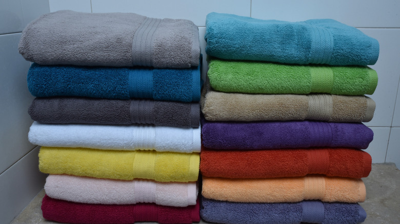 Multi-colored bath towels folded and stacked into two piles.